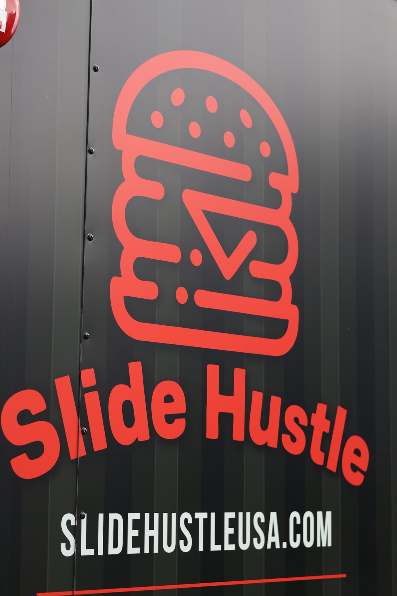 Red Slide Hustle burger logo and lettering on the food truck
